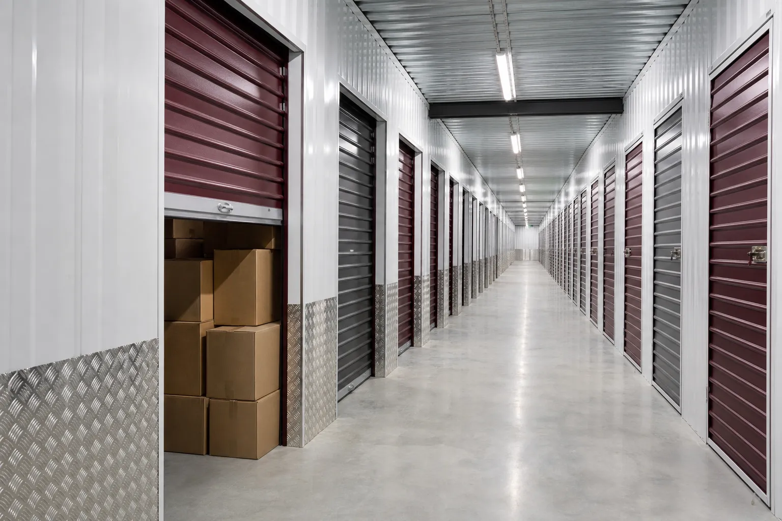 Couloir intérieur surveillé, longue rangée de portes de box de stockage en acier